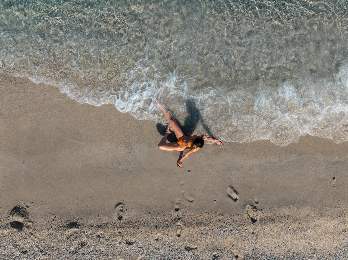 Bikini Top Turquoise Bay Arancione sostenibile Deganis Beachwear in piscina tramonto drone